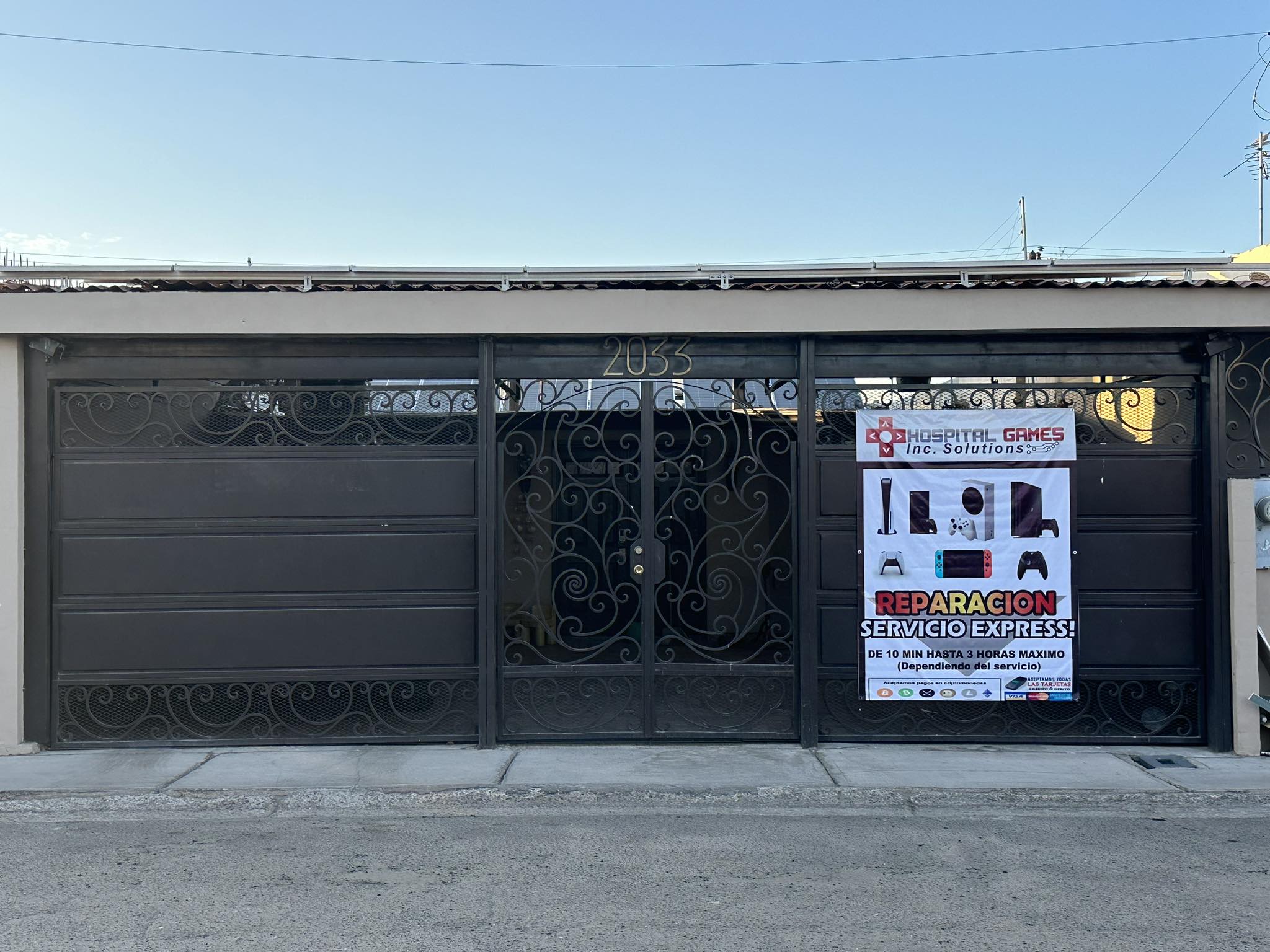 Fachada de Hospital Games en Av. Río Ameca 2033, Mexicali: portón negro con el número 2033 y lona del negocio.